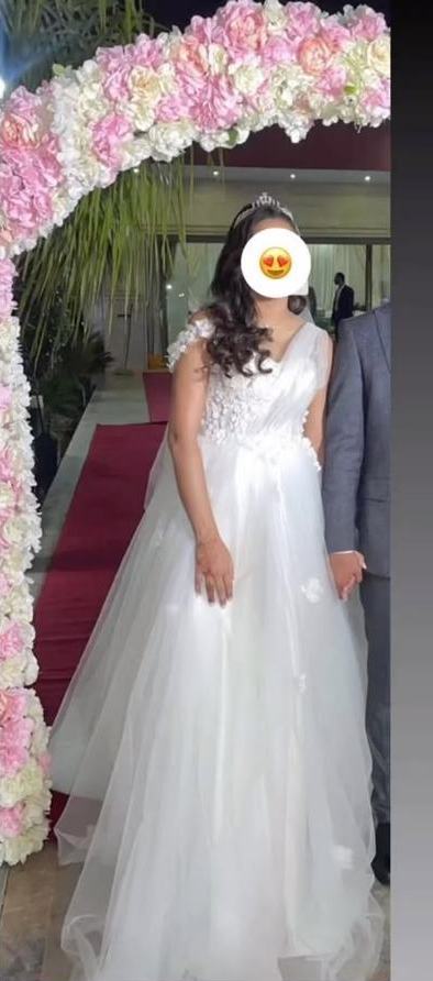 Hala en robe Bridal Glow sous une arche florale