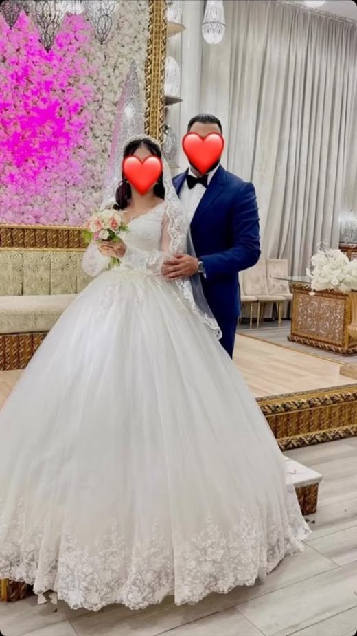 Salma en robe Bridal Glow sous une arche florale